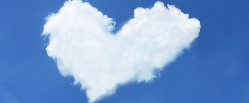 Moln i form av ett hjärta på blå himmel