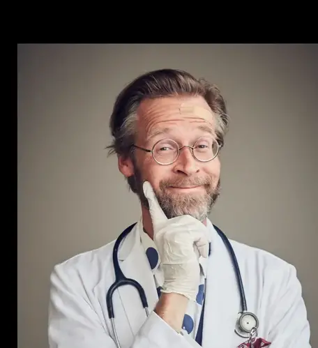 Henrik Widegren från Fråga Lund i prickig skjorta, stetoskop och läkarrock ler mot kameran